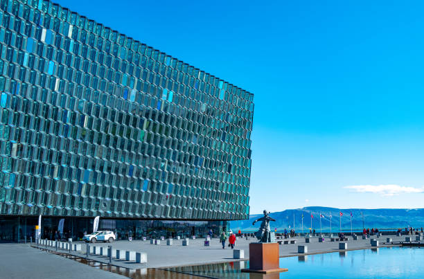 Reykiavik, Iceland - May 31, 2019: The square with monument in front of the  modern crystal and steel architectures of the Harpa Cultural Center