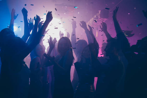 Close up photo of many party people dancing purple lights confetti flying everywhere nightclub event hands raised up wear shiny clothes Close up photo of many party people dancing purple lights confetti flying everywhere nightclub event hands raised up wear shiny clothes prom photos stock pictures, royalty-free photos & images