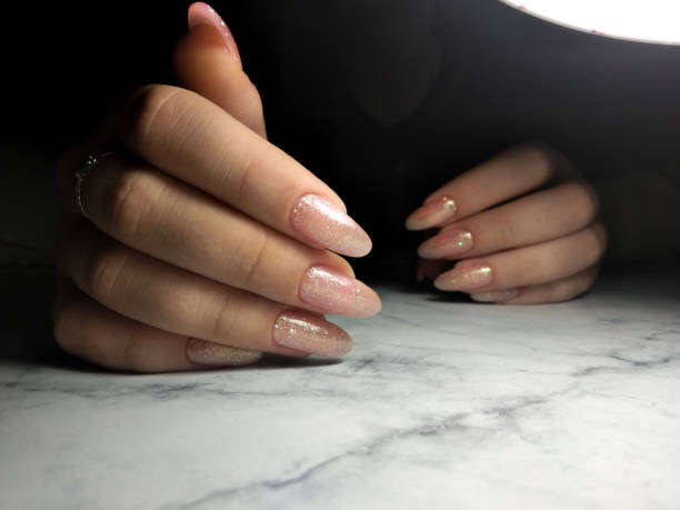istock Stylish manicure in pink color with sequins 1170934597