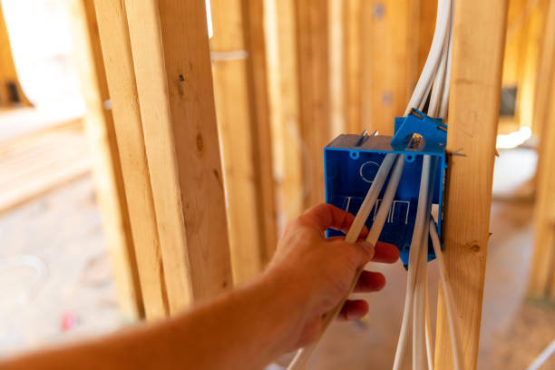 Hand installing electrical wiring in new home under construction stock photo