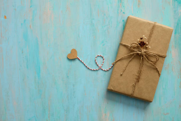 Gift box in recycled paper on wood background