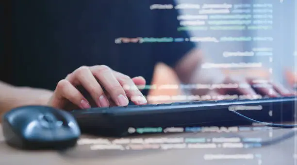 close up programmer student man hand typing on keyboard at computer desktop  to input code language into software for study bug and defect of system in classroom , development of technology concept