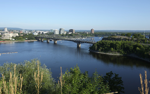 View from Parliament Hill of the steel truss cantilever bridge connecting Quebec and Ontario. Summer morning.