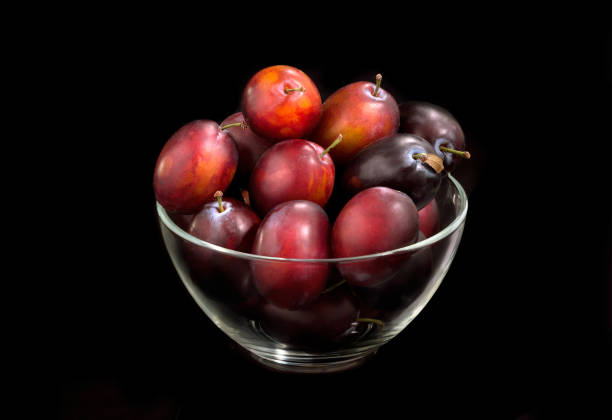 prugna fresca in una lastra trasparente su sfondo nero - red potato isolated raw potato raw foto e immagini stock