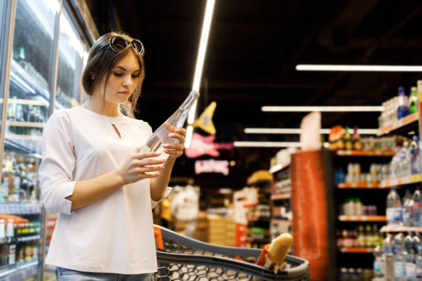 jovencita bonita está comprando en una gran tienda. la chica compra comida en el supermercado. chica elige bebidas - department store shopping teenage girls clothing fotografías e imágenes de stock