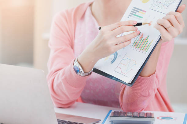 istock Midsection Of Businesswoman Holding Graph On Table 1170944701