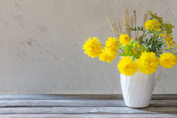 istock yellow summer flowers in jug on white background 1170949423