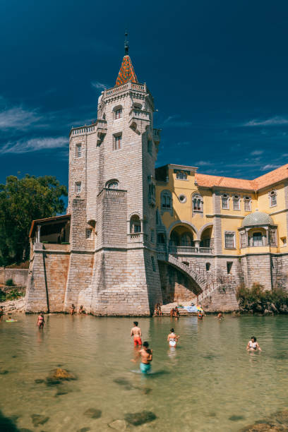 i turisti nuotano in un ruscello che si affaccia sull'esterno del museo del castello di condes de castro guimaraes a cascais, in portogallo - ghotic foto e immagini stock