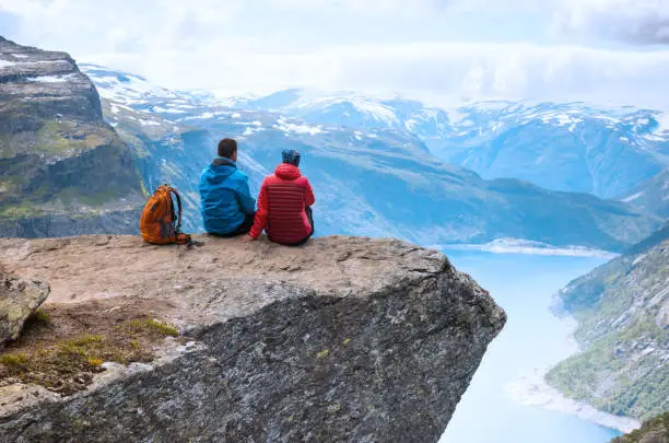 Photo of Couple sitting view on the way to Trolltunga, Norway Concept of freedom and success