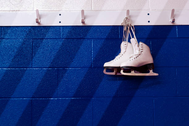istock Figure skates hanging over gradient blue wall in locker room with copy space 1170952968