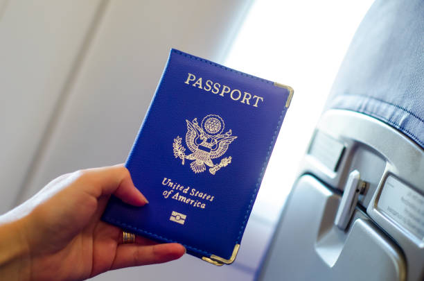istock Hand holding U.S. passport inside airplane cabin. 1170953713