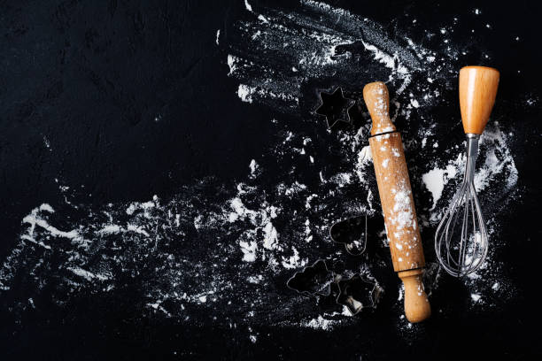 istock Rolling pin, cookie cutters and spatula with flour on dark black baking background, top view, copy space for text, menu, recipe. Flat lay. 1170956482