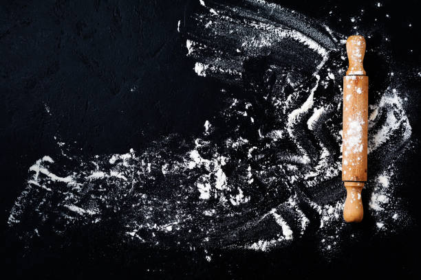 istock Rolling pin with flour on dark black baking background, top view, copy space for text, menu, recipe. Flat lay. 1170956746