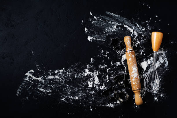 istock Rolling pin, cookie cutters and spatula with flour on dark black baking background, top view, copy space for text, menu, recipe. Flat lay. 1170956825
