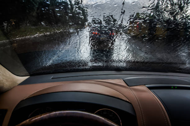 車は雨の中に入る。内側からの眺め。フロントガラスに雨滴が視界不良と危険運転 - on the inside looking out ストックフォトと画像