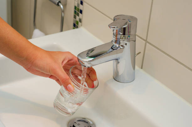 istock Female hands pouring water in glass cup 1170959039