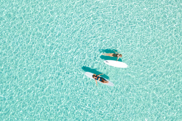 Two Women on Paddle Board in Blue Ocean