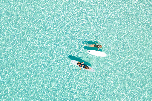 Two Women on Paddle Board in Blue Ocean