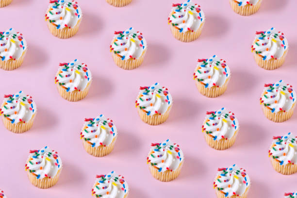 파스텔 핑크 컬러 배경에 컵 케이크 패턴 - muffin cake isolated small 뉴스 사진 이미지