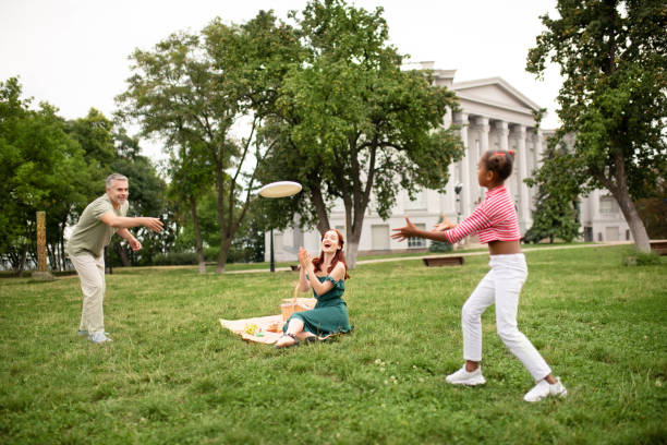 istock Dark-skinned daughter catching frisbee while playing with daddy 1170967669