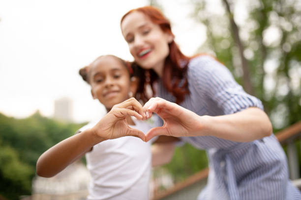 istock Daughter and mother making heart with their hands 1170967747