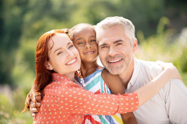 istock Beaming wife hugging her husband and daughter 1170968315