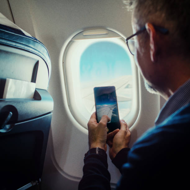 istock Male taking a photo with smartphone on plane 1170969651