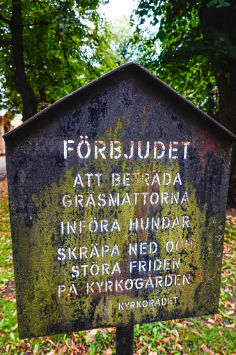 Stockholm, Sweden A forbidden (walk on grass, dogs, leave garbage) sign at the Klara Church in downtown.