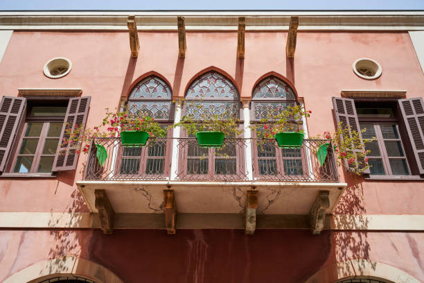 Rome, Italy - May 2, 2016: Piazza Navona street sign in Rome, Italy against an old building with a balcony with traditional Southern European window shutters. The balcony is decorated with white and pink flowers. 