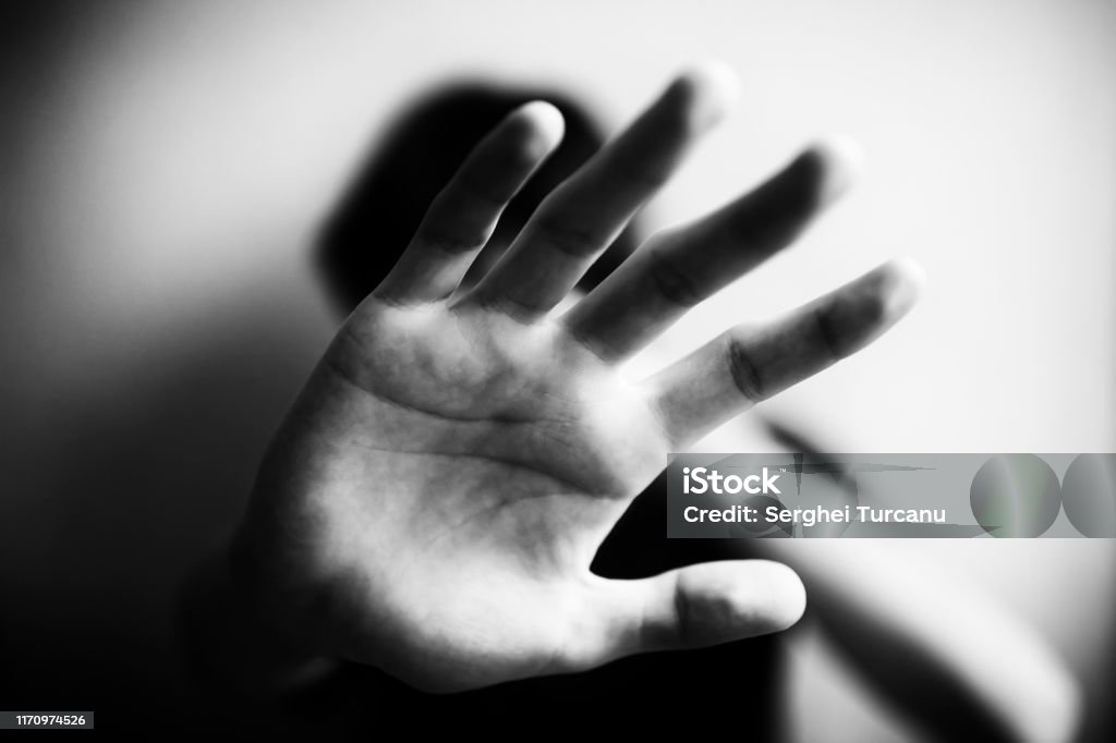 18 years old guy defends himself with his palm 18 years old guy defends himself with his palm isolated Domestic Violence Stock Photo