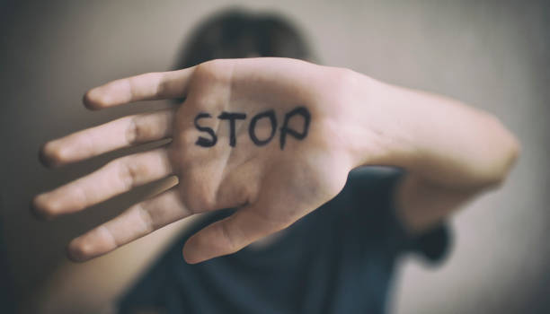 ein 18-jähriger kerl schützt sich mit seiner hand mit der aufschrift stop - stopp geste fotos stock-fotos und bilder