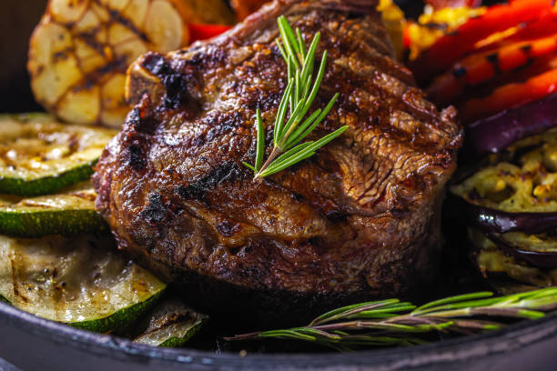 saftiges steak und gegrilltes gemüse in einer pfanne. nahaufnahme - skirt steak steak close up grilled stock-fotos und bilder