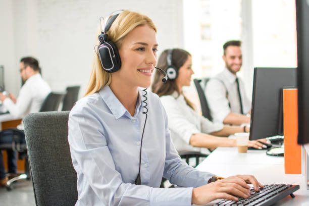 istock Cheerful blonde help-desk operator in headset working in call center. 1170978109