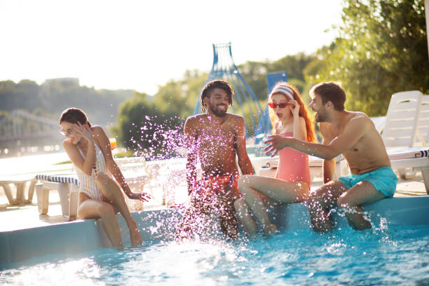 istock Boyfriend splashing water on girlfriend while having rest near pool 1170978264