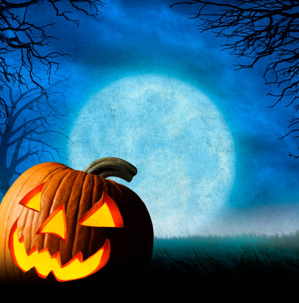 istock Jack O'Lantern Sits In Front Of Rising Full Moon 1170978324