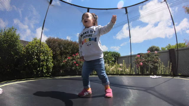 Little child enjoys jumping on trampoline