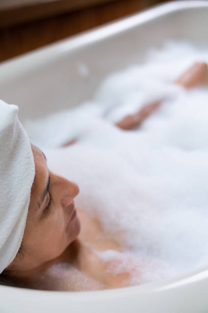 istock Woman taking bubble bath with brass faucet 1170979456