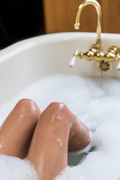 istock Woman taking bubble bath with brass faucet 1170979460
