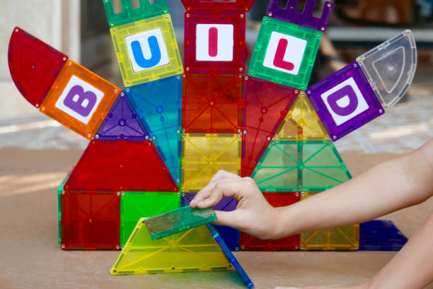 Children's colorful magnetic building tile toys in a wall structure, spelling out the word \