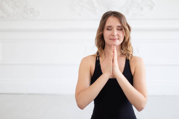istock Smiling woman meditates holding hands on her chest. Empty space for text 1170981860