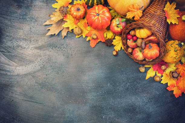istock Decorated autumn cornucopia with pumpkins and leaves on the rustic background 1170981900