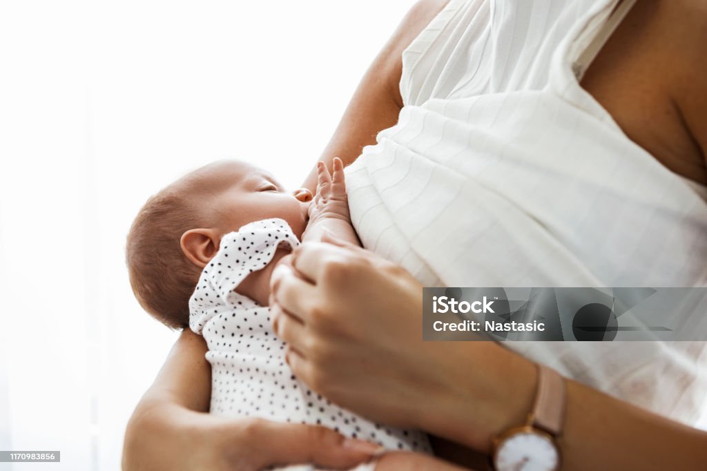 Mother breastfeeding and holding newborn baby Mother breastfeeding and hugging newborn baby Breastfeeding Stock Photo