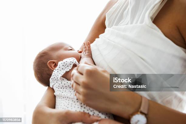 Mother Breastfeeding And Holding Newborn Baby Stock Photo - Download Image Now - Breastfeeding, Breast Milk, Baby - Human Age