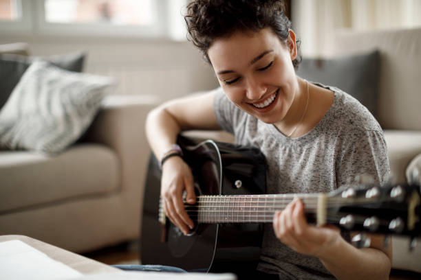 istock Smiling girl playing a guitar and enjoying 1170983991