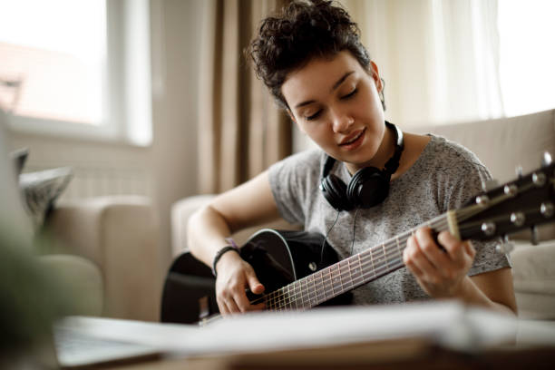 istock Smiling girl playing a guitar and enjoying 1170984032