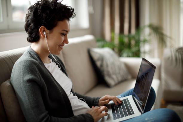 istock Young woman enjoying good music while working on laptop 1170984232