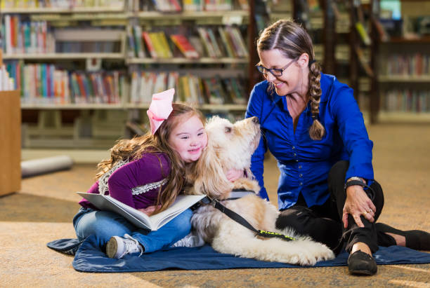 istock Girl with down syndrome in library hugging therapy dog 1170986953