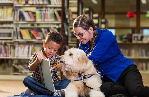 istock Mixed race boy reading in library with therapy dog 1170987567