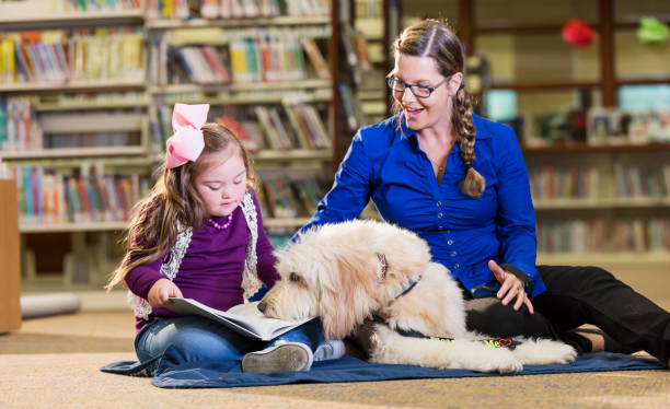 istock Girl with down syndrome in library with therapy dog 1170987614