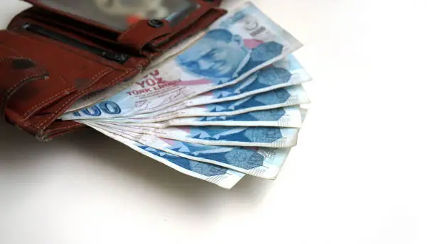 Photo of money wallet and 100 Turkish Lira banknotes,